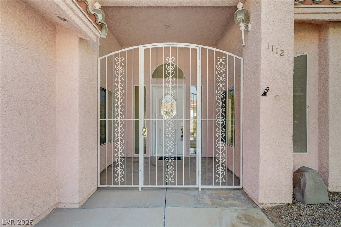 1112 Boletus Drive, Henderson, NV 89011 An arched wrought iron gate secures the stuccoed entryway leading to the front door.