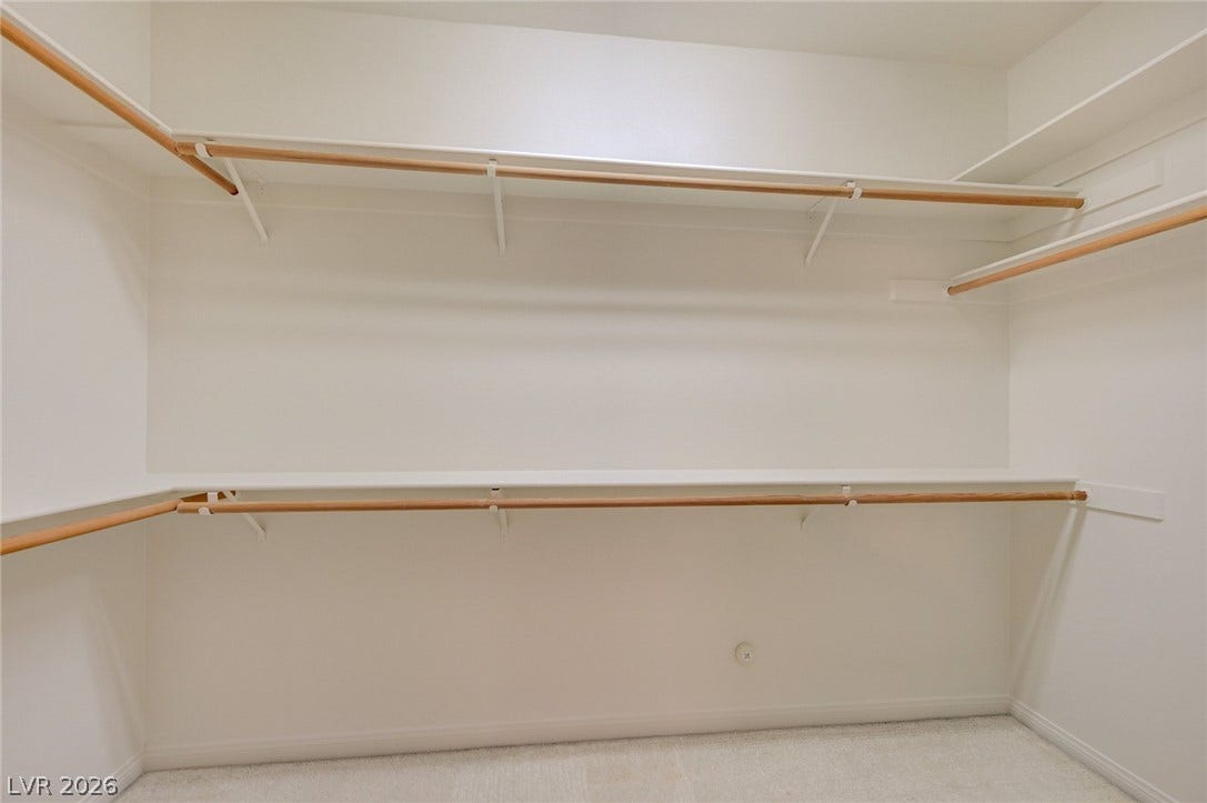 1112 Boletus Drive, Henderson, NV 89011 Ample built-in shelving and hanging rods maximize storage in this carpeted walk-in closet.