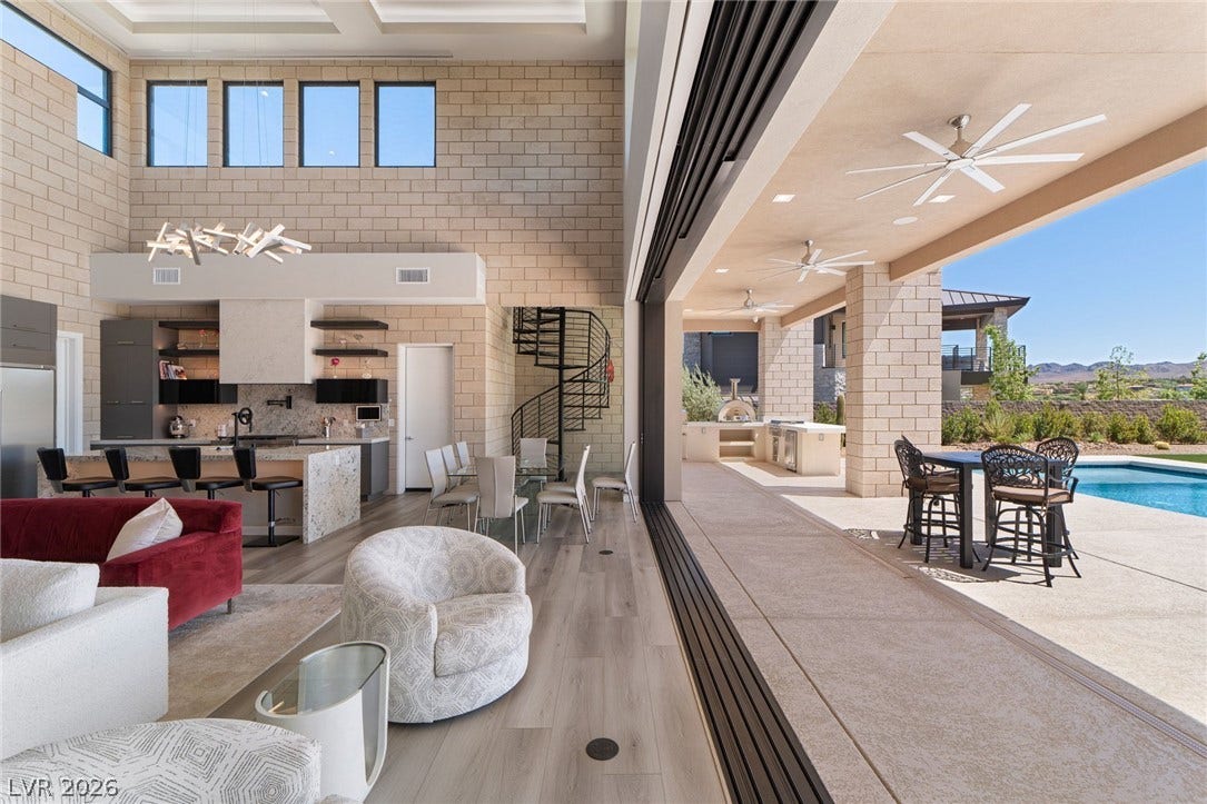 37 Reflection Shores Lane, Henderson, NV 89011 Retractable glass walls seamlessly merge the high-ceilinged interior with a spacious outdoor pool deck.