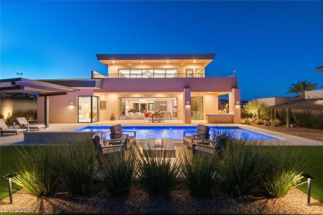 37 Reflection Shores Lane, Henderson, NV 89011 An inviting backyard oasis centers around a sparkling swimming pool, built-in kitchen, and fire pit.