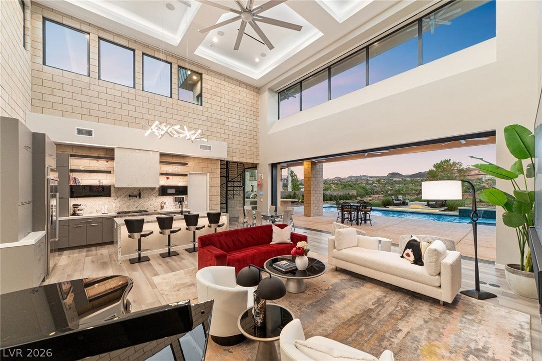 37 Reflection Shores Lane, Henderson, NV 89011 Double-height ceilings and massive sliding glass walls frame soaring desert mountain views.