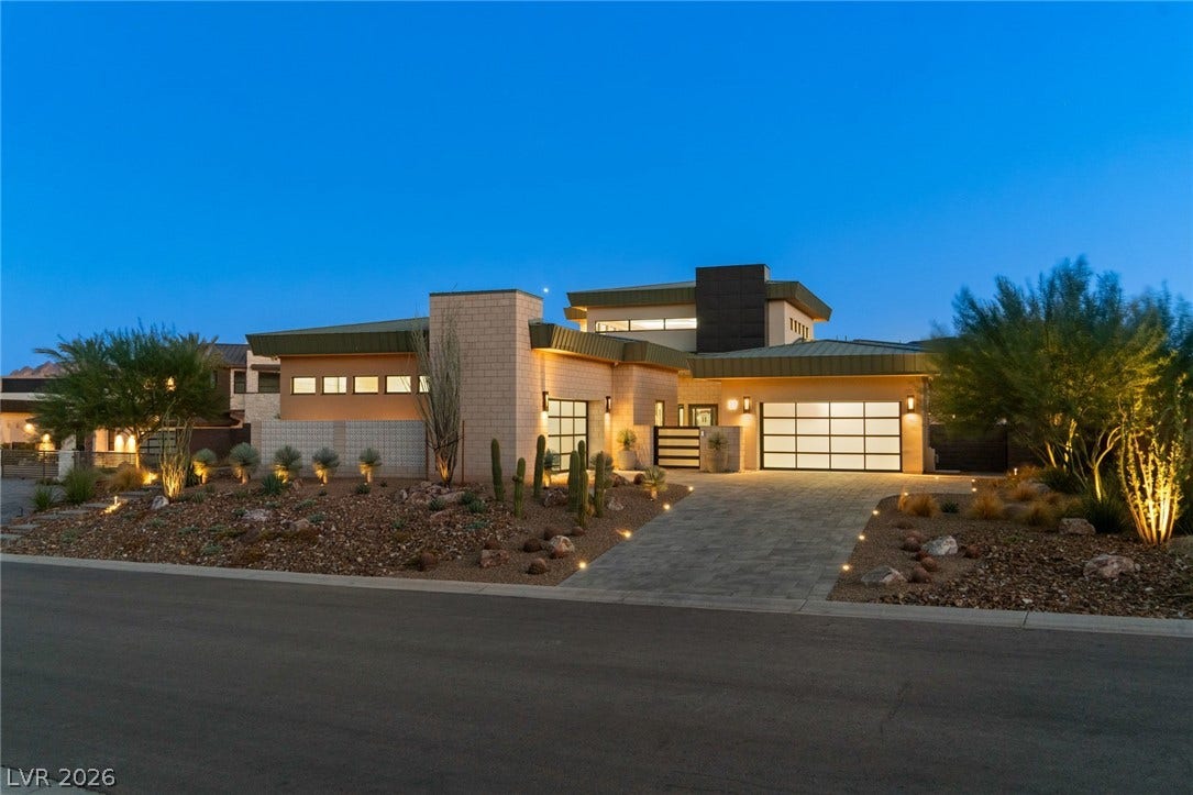 37 Reflection Shores Lane, Henderson, NV 89011 Dramatic modern architecture stands out against the evening sky with illuminated pathways and desert landscaping.