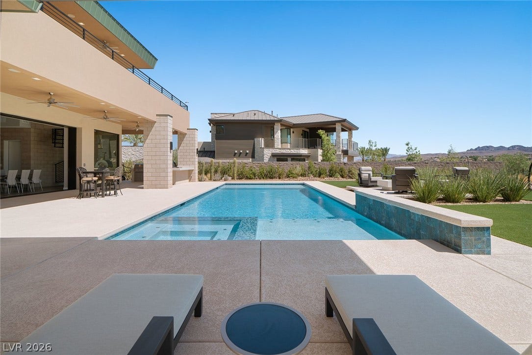 37 Reflection Shores Lane, Henderson, NV 89011 An inviting swimming pool and integrated spa sit surrounded by spacious stone decking.