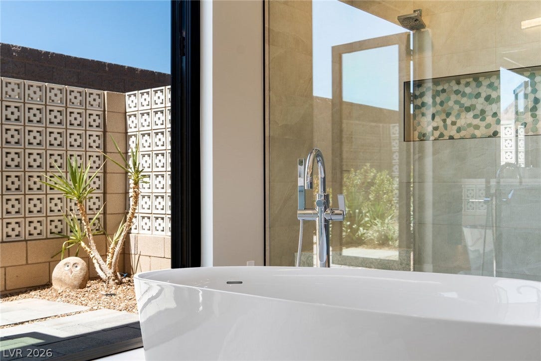 37 Reflection Shores Lane, Henderson, NV 89011 Floor-to-ceiling glass wall frames peaceful courtyard views from the deep soaking tub.