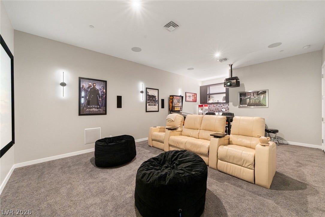 37 Reflection Shores Lane, Henderson, NV 89011 Recessed lighting and wall sconces illuminate this comfortable carpeted home theater space.