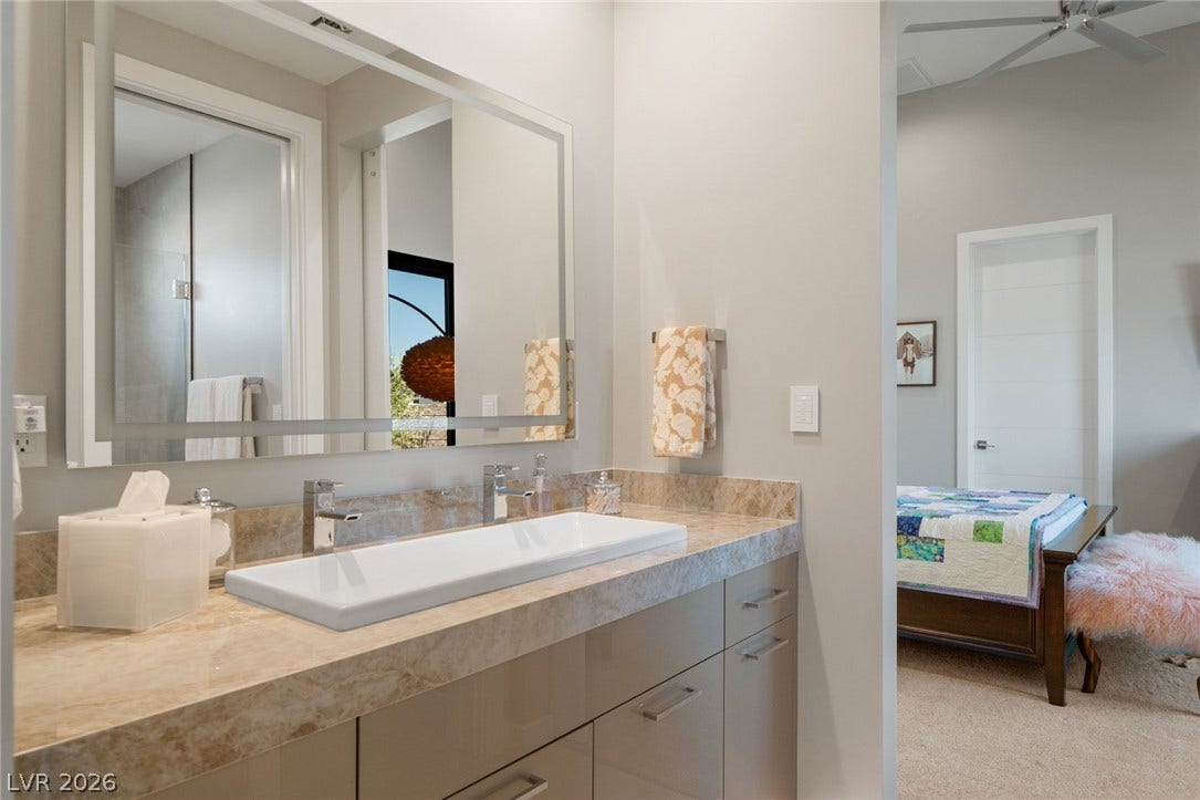 37 Reflection Shores Lane, Henderson, NV 89011 A stone counter with dual faucets highlights this modern bathroom vanity area.