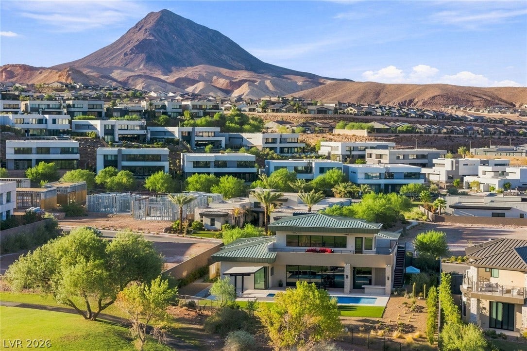 37 Reflection Shores Lane, Henderson, NV 89011 An aerial view showcases modern multi-level architecture nestled against a dramatic mountain backdrop.