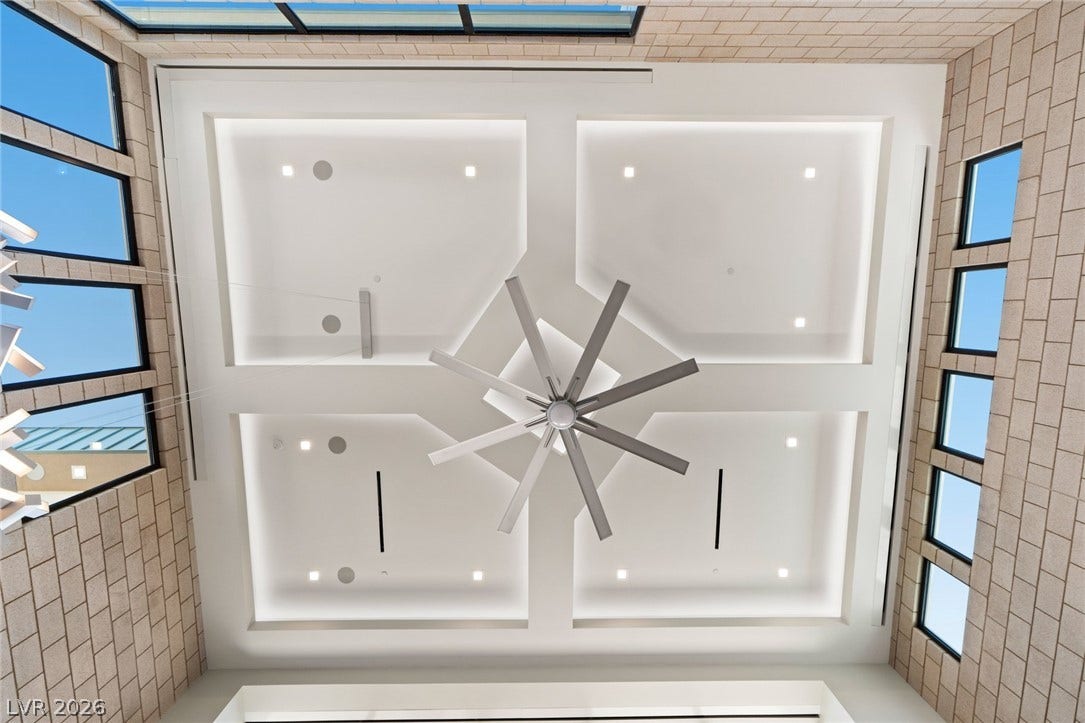 37 Reflection Shores Lane, Henderson, NV 89011 A striking geometric coffered ceiling anchors this soaring space surrounded by textured brick walls.