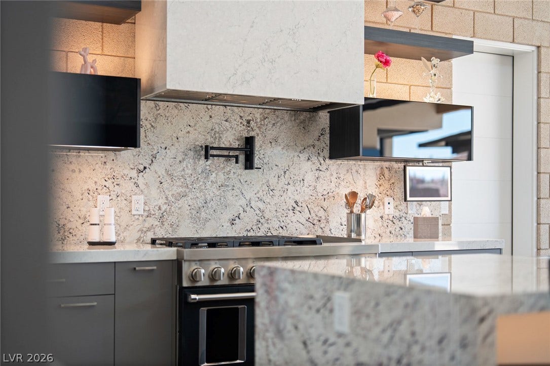 37 Reflection Shores Lane, Henderson, NV 89011 Striking stone backsplashes and premium appliances anchor this contemporary culinary workspace.