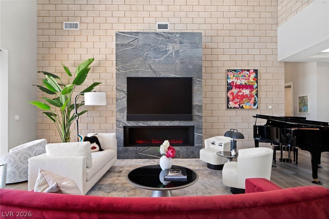 37 Reflection Shores Lane, Henderson, NV 89011 Soaring block walls and a sleek floor-to-ceiling fireplace anchor this striking great room.