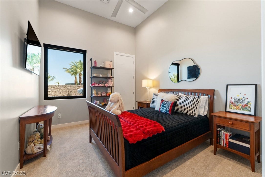 37 Reflection Shores Lane, Henderson, NV 89011 A high, vaulted ceiling and tall window define this comfortable bedroom space.