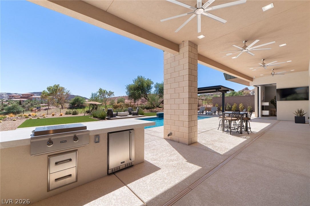 37 Reflection Shores Lane, Henderson, NV 89011 A spacious covered patio features a built-in outdoor kitchen overlooking the private swimming pool.