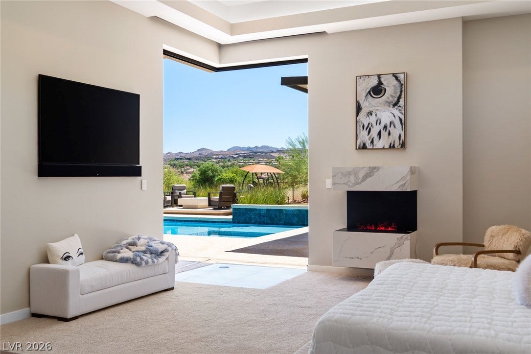37 Reflection Shores Lane, Henderson, NV 89011 Retractable glass doors connect this primary bedroom to a private pool and patio.
