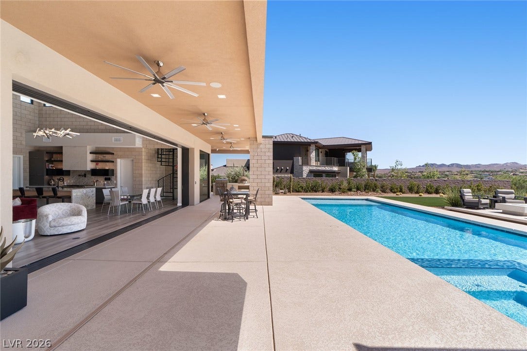 37 Reflection Shores Lane, Henderson, NV 89011 Seamless indoor-outdoor living flows effortlessly to a sparkling pool under clear desert skies.