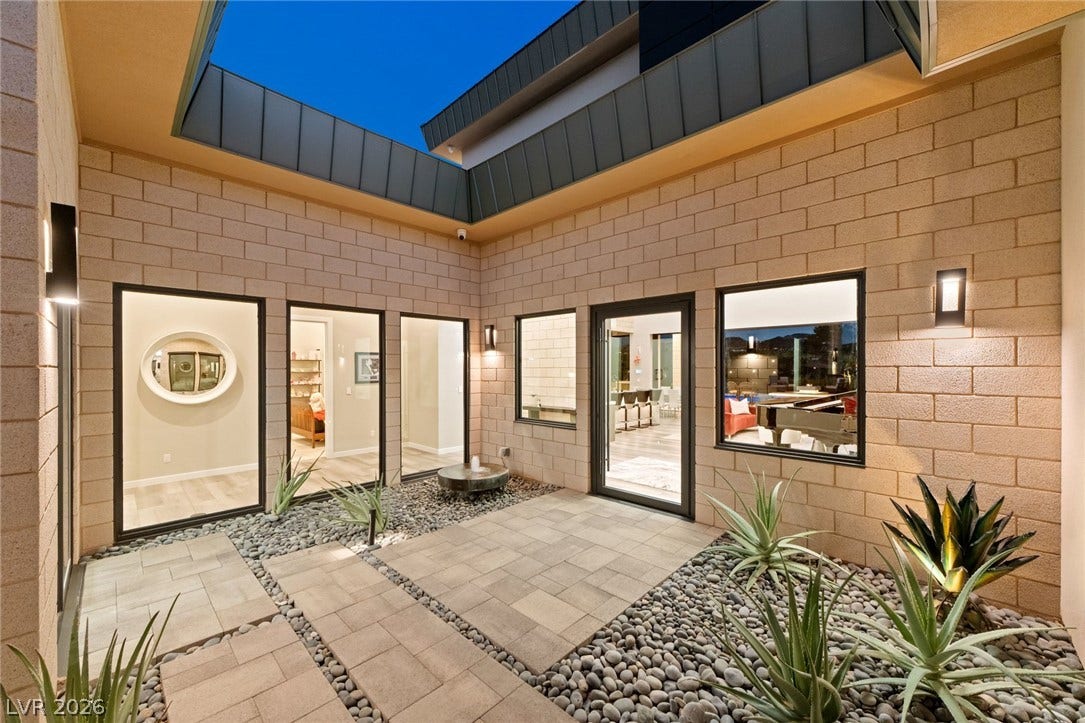 37 Reflection Shores Lane, Henderson, NV 89011 An open-air courtyard features modern concrete block walls and paved stone walkways.