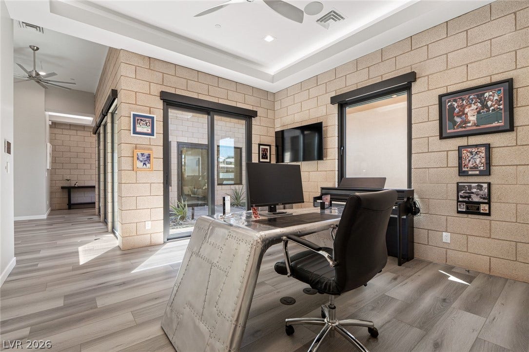 37 Reflection Shores Lane, Henderson, NV 89011 Exposed masonry blocks and sleek modern flooring define this distinctively styled home office workspace.