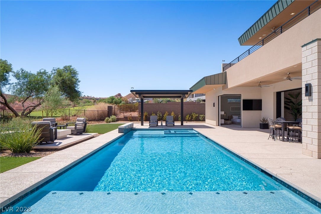 37 Reflection Shores Lane, Henderson, NV 89011 An inviting swimming pool and spacious stone patio anchor this modern outdoor entertaining area.