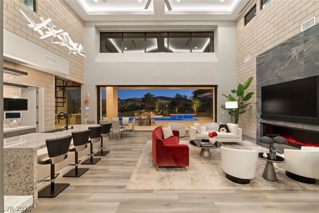37 Reflection Shores Lane, Henderson, NV 89011 Soaring ceilings and an integrated fireplace anchor this grand open-concept living space.