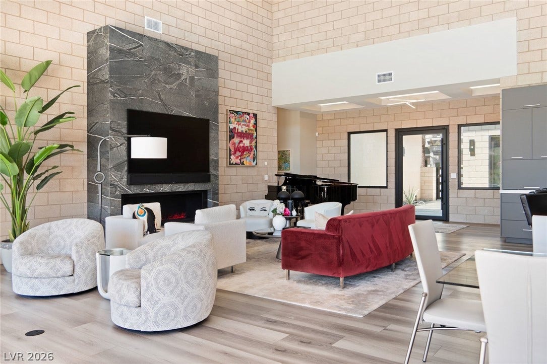 37 Reflection Shores Lane, Henderson, NV 89011 Towering ceilings and a massive stone fireplace anchor this airy, open-concept living space.