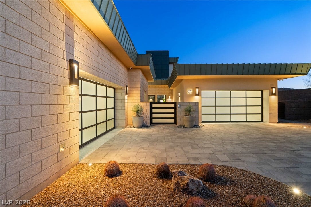 37 Reflection Shores Lane, Henderson, NV 89011 A spacious paved motor court is flanked by contemporary frosted glass garage doors.
