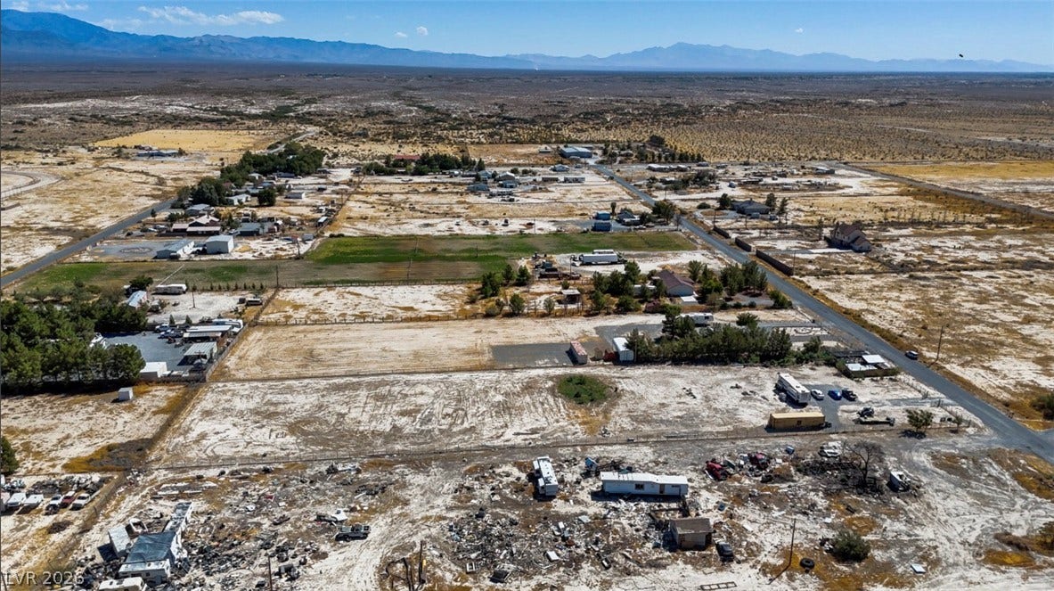 3160 Wall Street, Pahrump, NV 89061 Majestic mountain ridges frame a vast desert landscape under clear blue skies.
