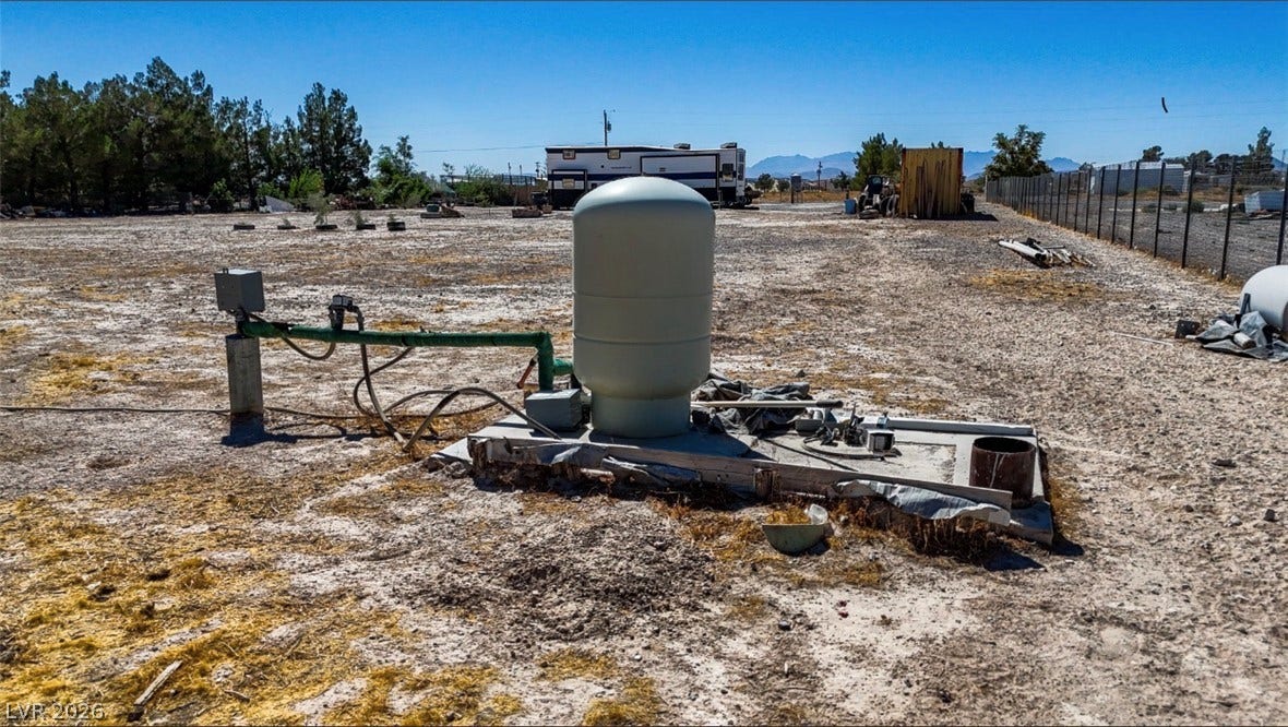 3160 Wall Street, Pahrump, NV 89061 An expansive dirt lot features a well with equipment under clear desert skies.
