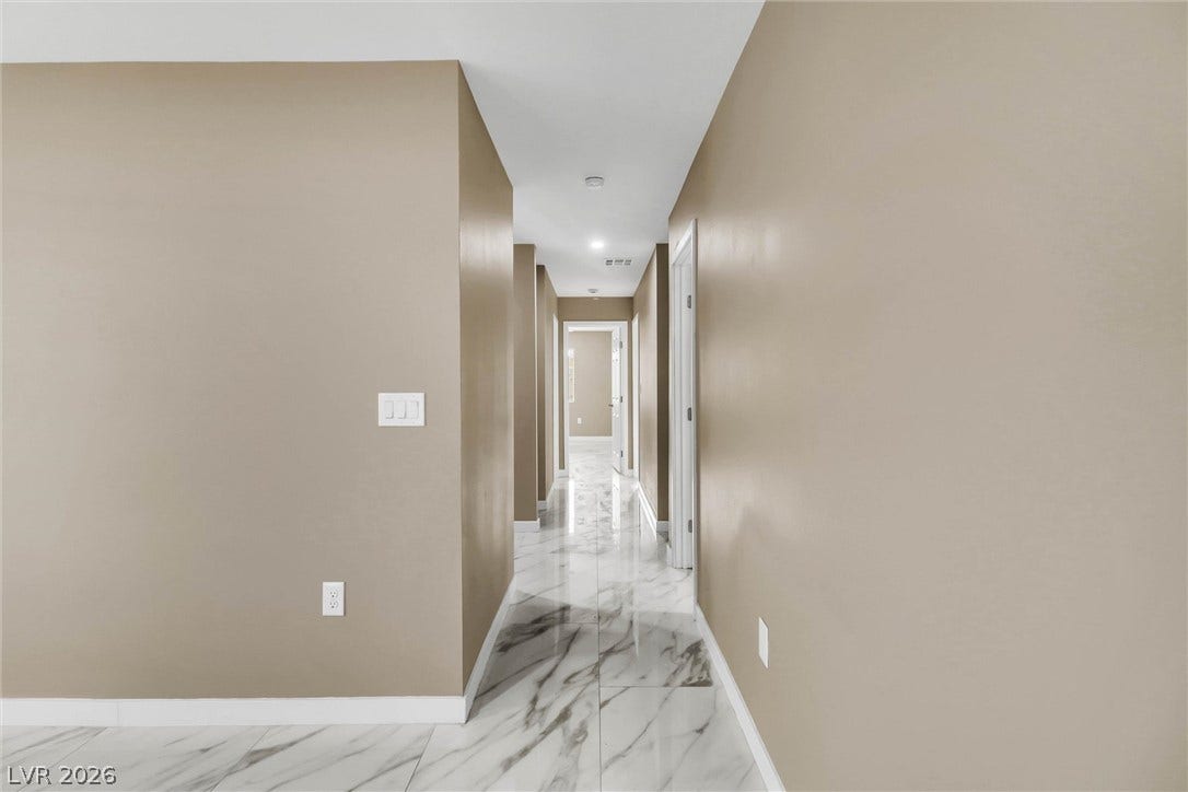 Gleaming polished tile floors guide the way through a clean, modern hallway layout.