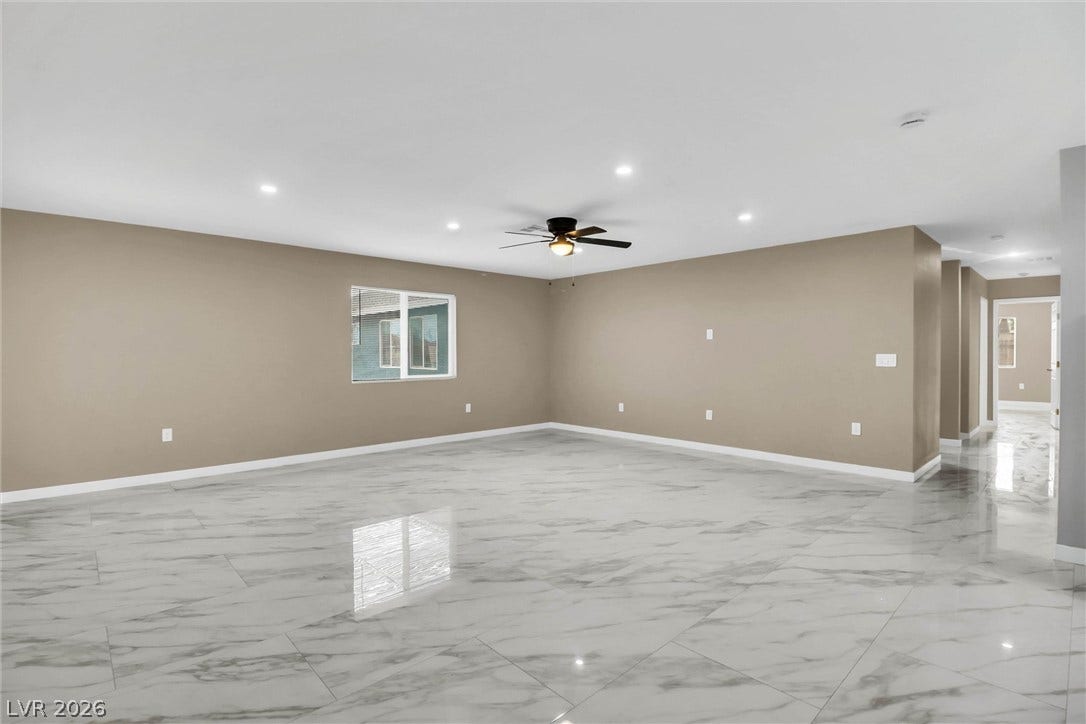 Polished tile flooring and recessed lighting define this versatile open living space.