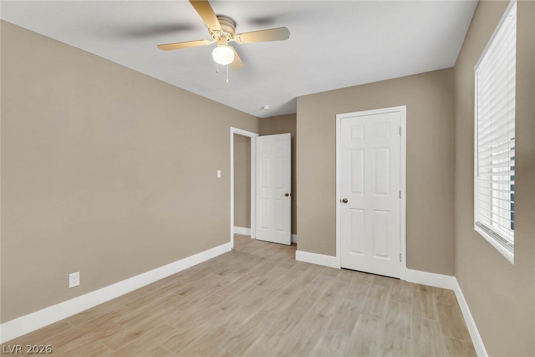 Smooth wood-look flooring and crisp white trim accent this comfortable secondary bedroom.