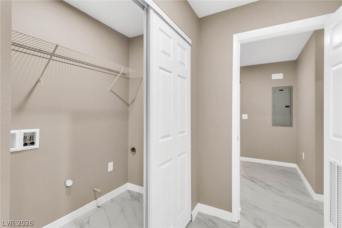 Polished tile floors and built-in wire shelving define this functional laundry closet.