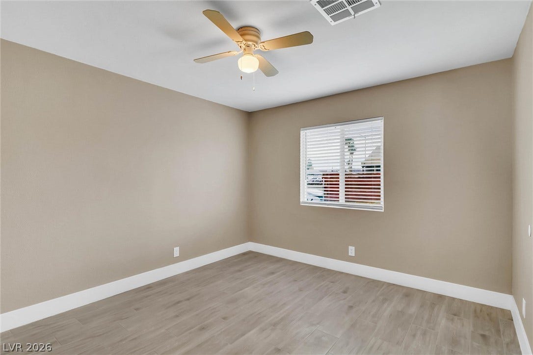Smooth wood-look tile flooring paired with crisp baseboards anchors this versatile space.