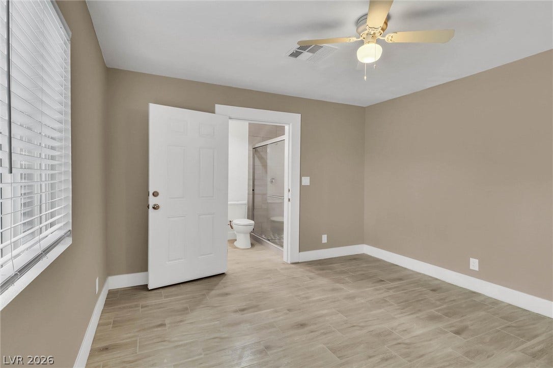 Wood-look tile flooring and neutral walls define this comfortable suite with an attached bath.