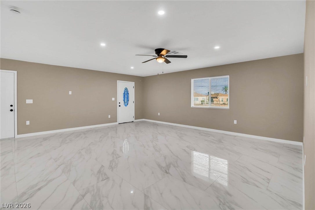 Polished tile flooring and recessed lighting define this versatile open living space.