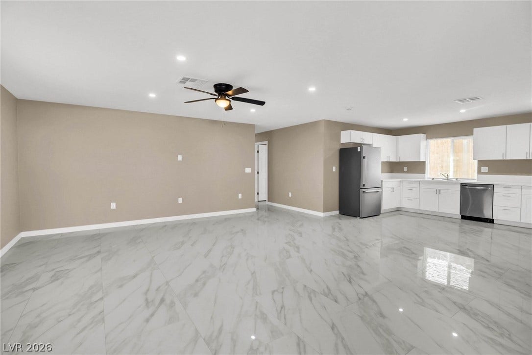 Gleaming polished tile floors span this open-concept layout connecting the living area and kitchen.