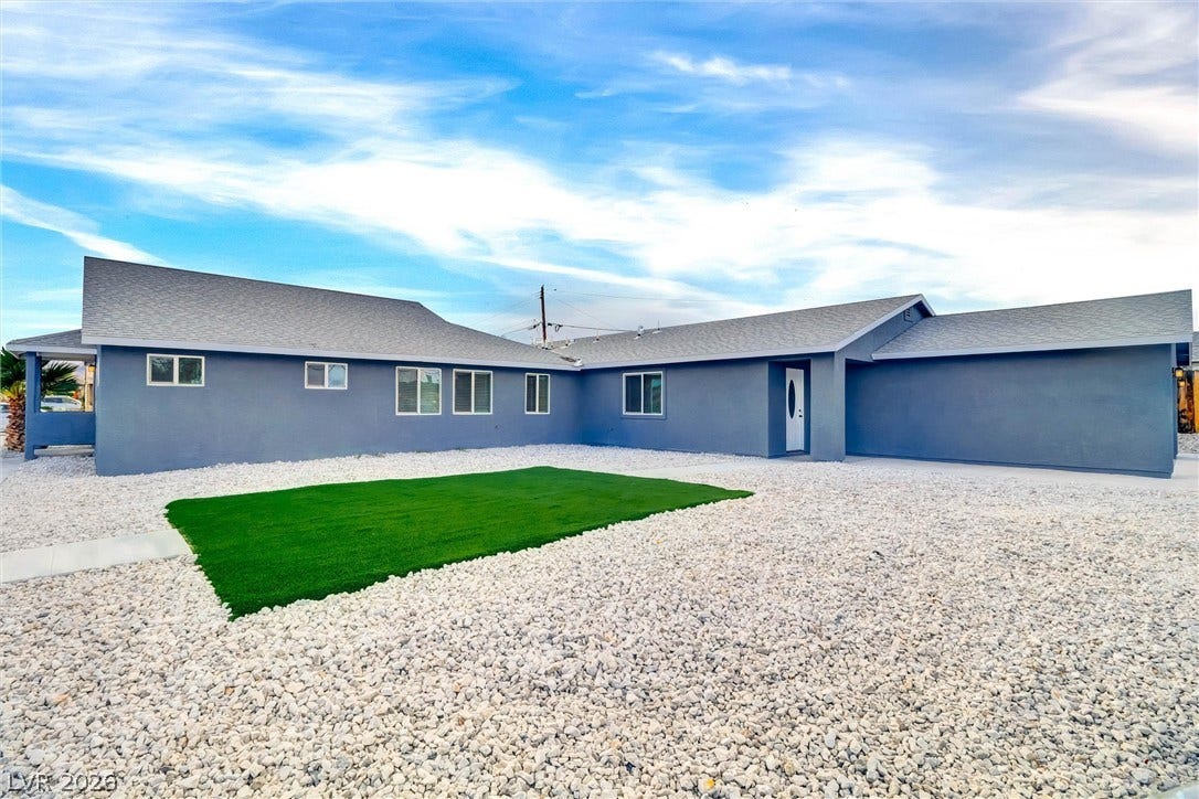 Gravel landscaping and a clean stucco exterior define this modern single-story residence.