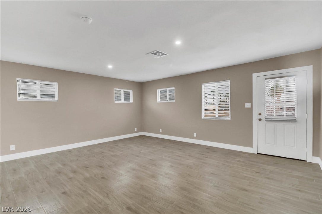 Recessed lighting and wood-look flooring enhance this versatile living space with private exterior access.