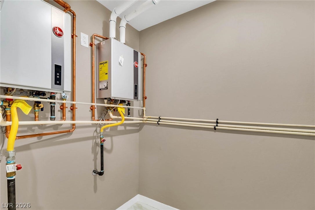 A dedicated utility space houses modern wall-mounted tankless water heaters and clean piping installations.
