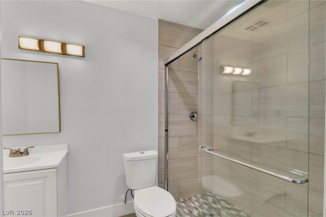 Clean lines and a spacious glass-enclosed shower define this updated bathroom.