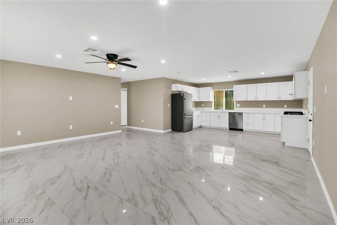 Polished tile flooring flows seamlessly through this open-concept layout connecting the kitchen and living areas.