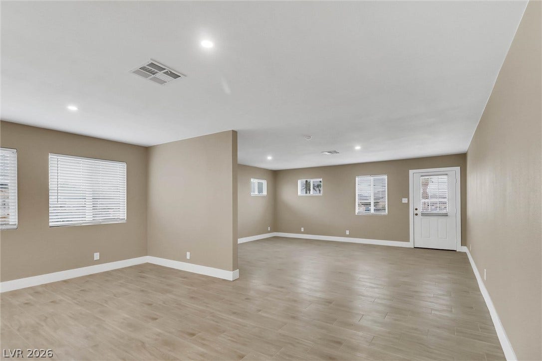 Smooth wood-look flooring and recessed lighting define this versatile open living space.