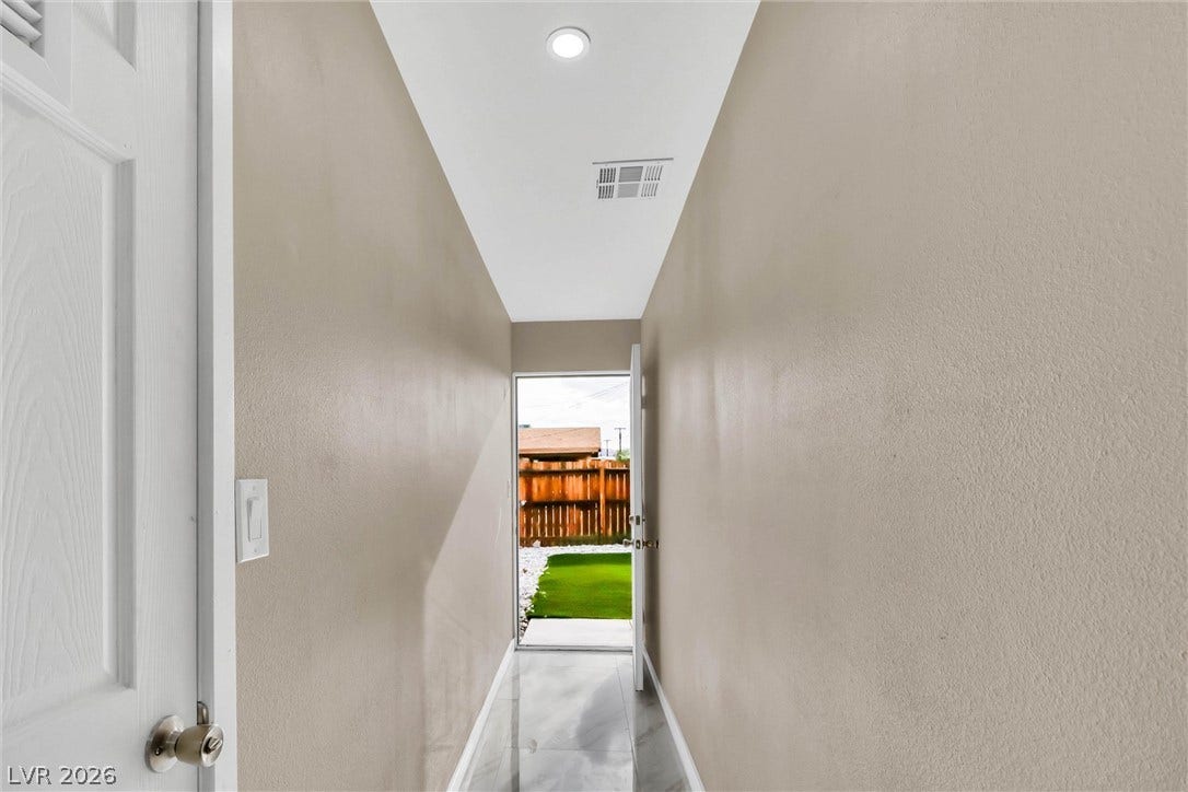 Gleaming tile floors line a long hallway leading directly to the backyard.