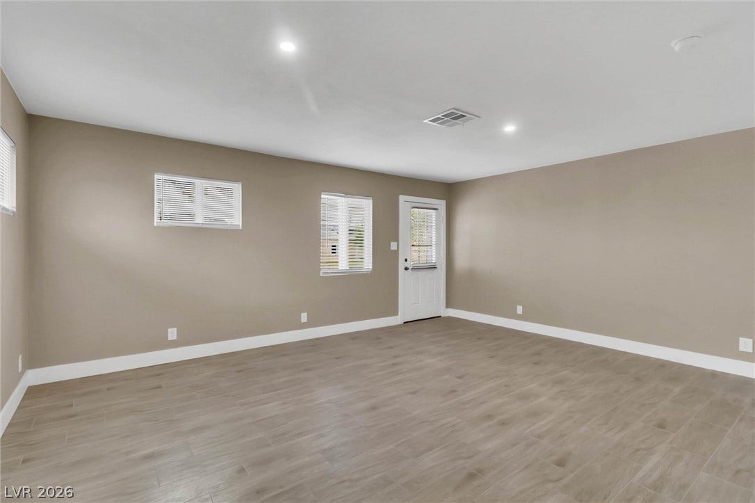 Smooth wood-look flooring and recessed lighting define this versatile living space.