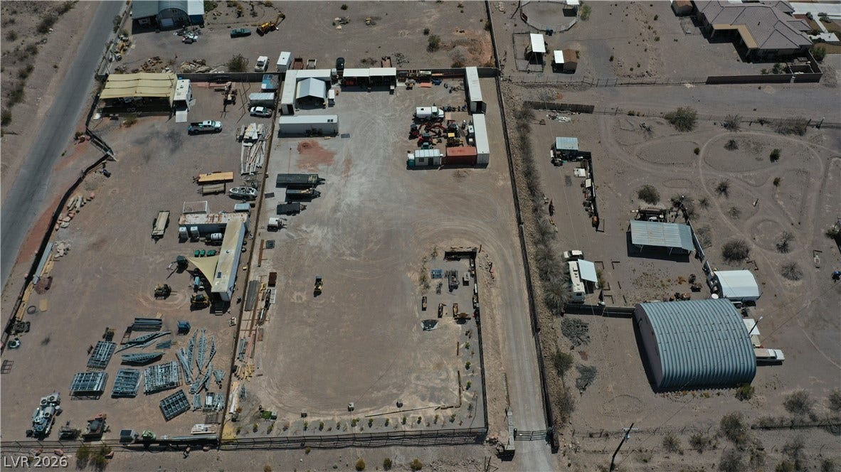 1111 E Warm Springs Road, Henderson, NV 89015 An aerial perspective showcases a fully fenced yard with spacious outbuildings and secure gated access.