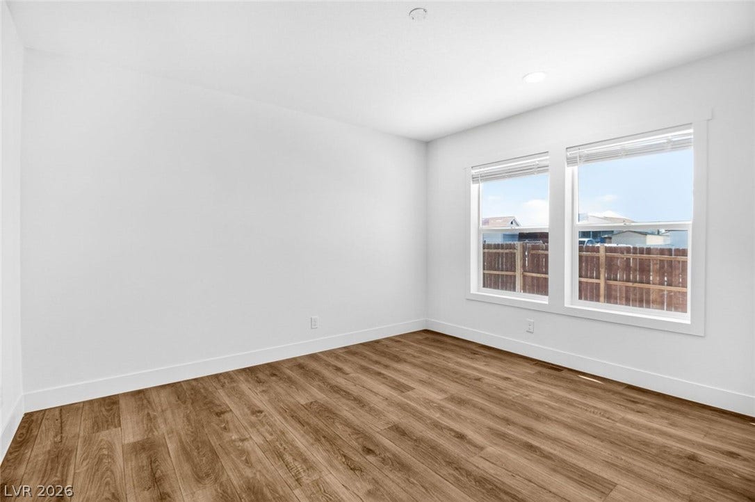 2258 Toiyabe Street, Las Vegas, NV 89156 Rich wood-inspired flooring and generous natural light define this versatile secondary bedroom space.