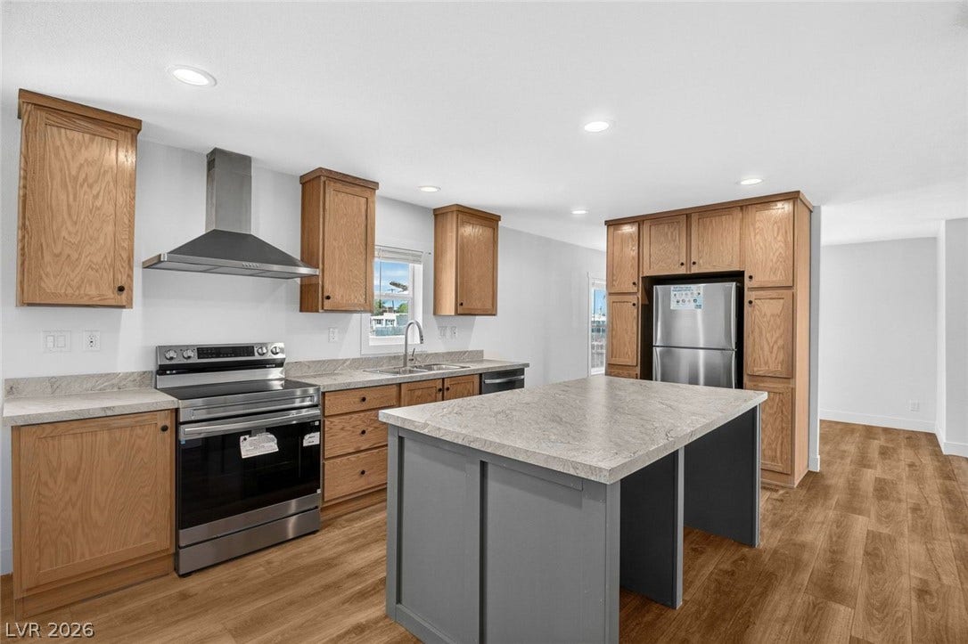 2258 Toiyabe Street, Las Vegas, NV 89156 Warm wood cabinetry and durable stone counters define this modern kitchen with a central island.