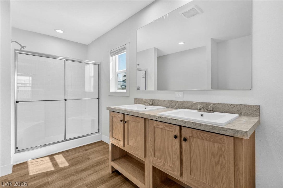 2258 Toiyabe Street, Las Vegas, NV 89156 A modern double vanity anchors this bright bathroom featuring a spacious glass-enclosed shower.