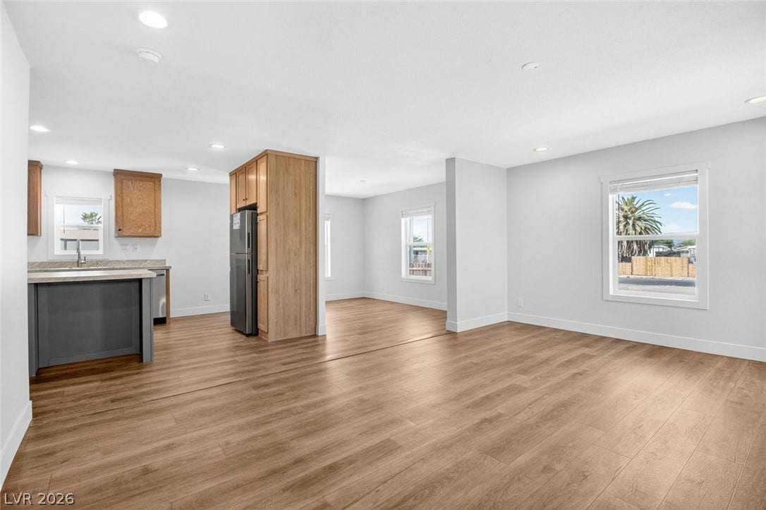 2258 Toiyabe Street, Las Vegas, NV 89156 Warm wood-style flooring runs throughout this open-concept layout connecting the kitchen and living areas.