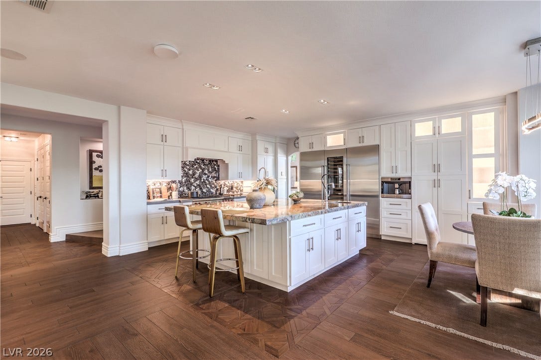 Expansive kitchen island with an oversized sink and separate vegetable sink, complemented by built-in Sub-Zero refrigerator, freezer and wine storage.