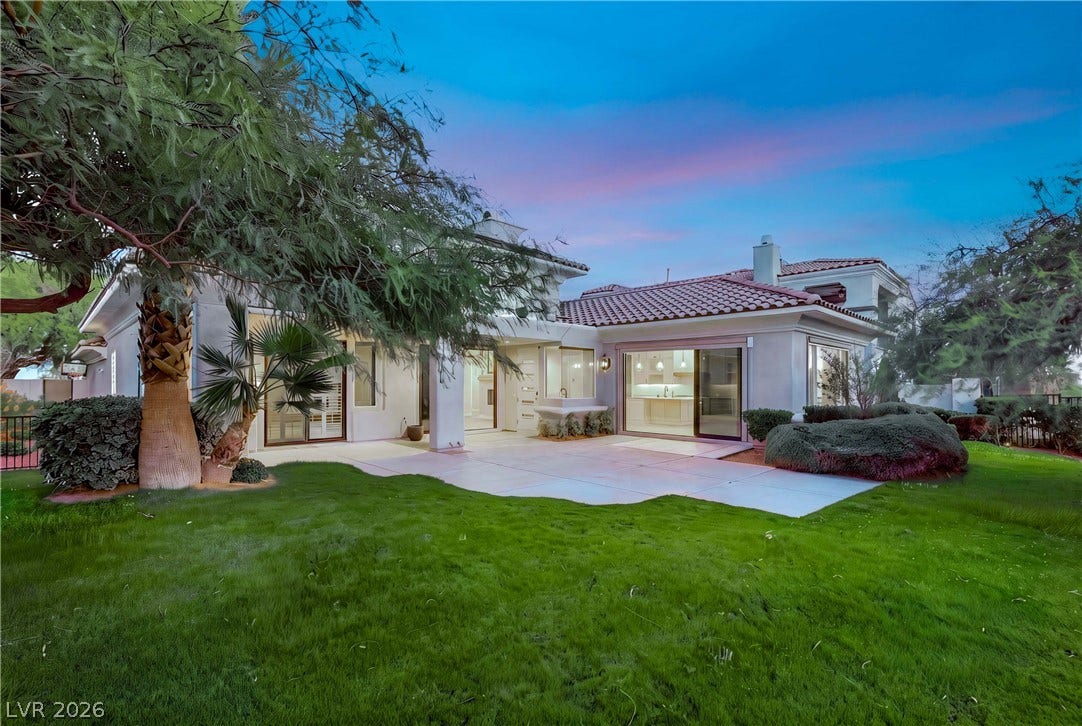 2575 Turtle Head Peak Drive, Las Vegas, NV 89135 A spacious stone patio and lush green lawn frame this elegant Spanish tile roof home.