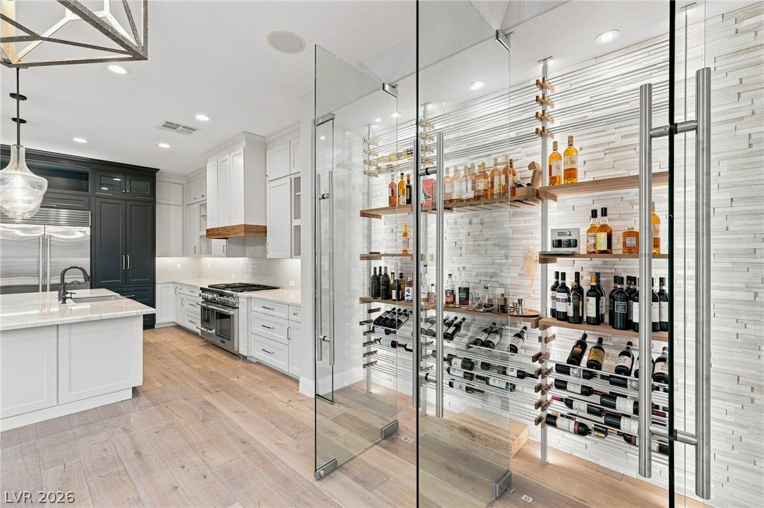 2575 Turtle Head Peak Drive, Las Vegas, NV 89135 A glass-enclosed wine storage display stands adjacent to the modern kitchen.